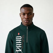 Man wearing a green sweatshirt with a brand logo on a white background