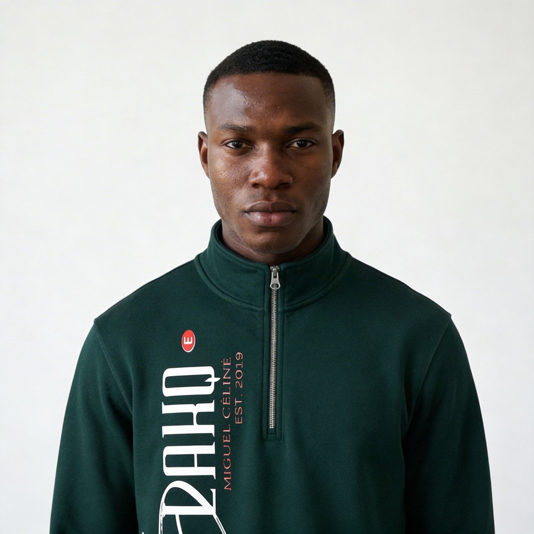 Man wearing a green sweatshirt with a brand logo on a white background