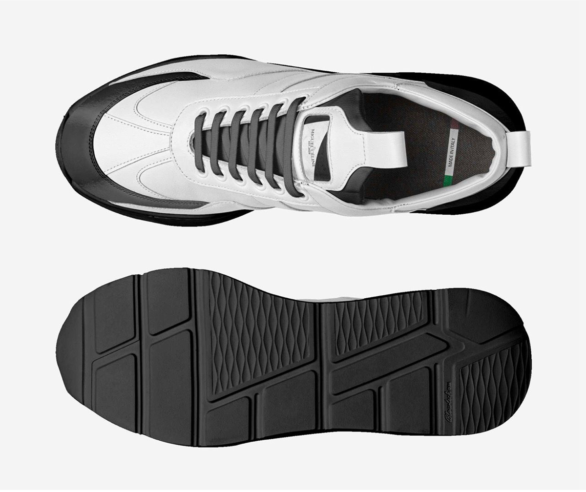 White sneaker with black sole on a light gray background